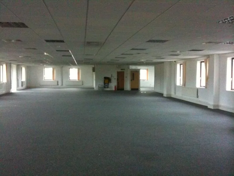 Empty carpeted office with bright windows, used as a credited Level 4 reference image